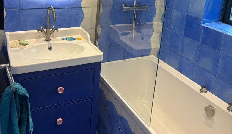A bathroom featuring a blue tile floor and a matching blue sink, creating a cohesive color scheme.